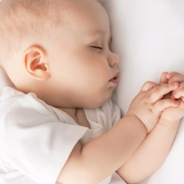 Carefree sleep little baby with a soft toy on the bed